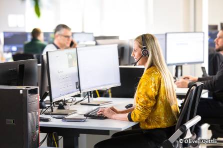 Mitarbeiterin mit Headset beim Arbeiten