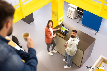 Mitarbeiter schaut von oben auf zwei Kollegen