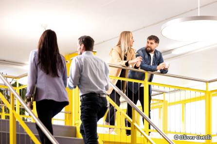 Zwei Mitarbeitende führen eine Koversation in der Kaffeepause