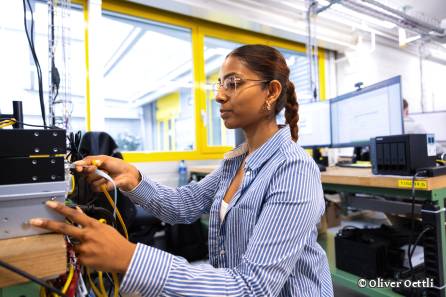 Mitarbeitende arbeitet mit Kabel