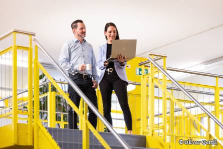 Zwei Mitarbeitende schauen auf Bildschirm